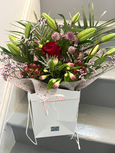 Bag of mixed flowers with single red rose